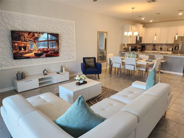 tiled living room with a notable chandelier and a fireplace