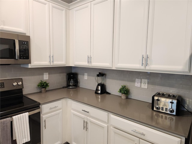 kitchen featuring white cabinetry, black range with electric stovetop, and backsplash