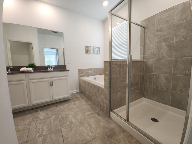 bathroom with vanity, a wealth of natural light, and independent shower and bath