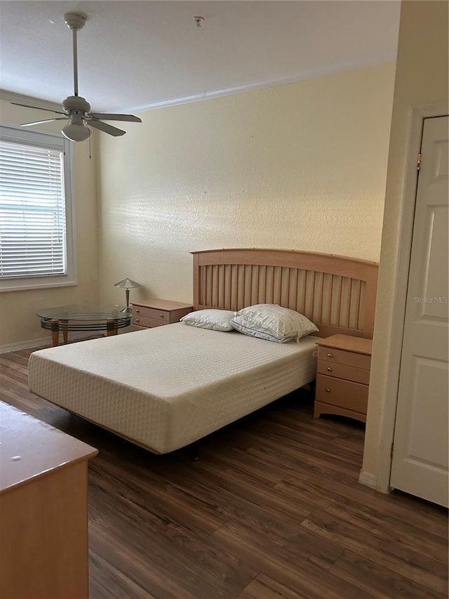 bedroom featuring ceiling fan and dark hardwood / wood-style flooring