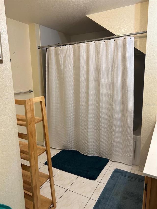 bathroom with shower / tub combo with curtain, tile patterned floors, and a textured ceiling