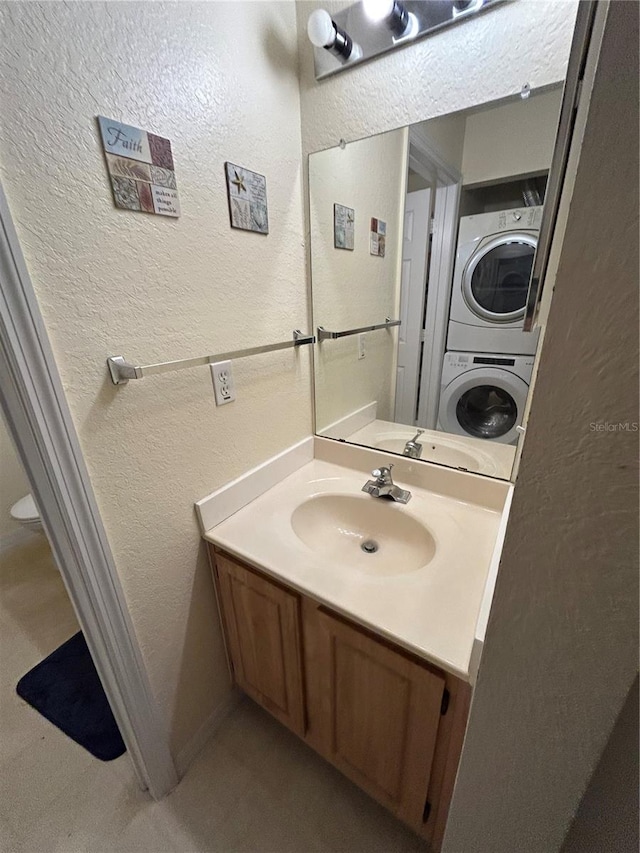 bathroom featuring vanity and stacked washer / drying machine