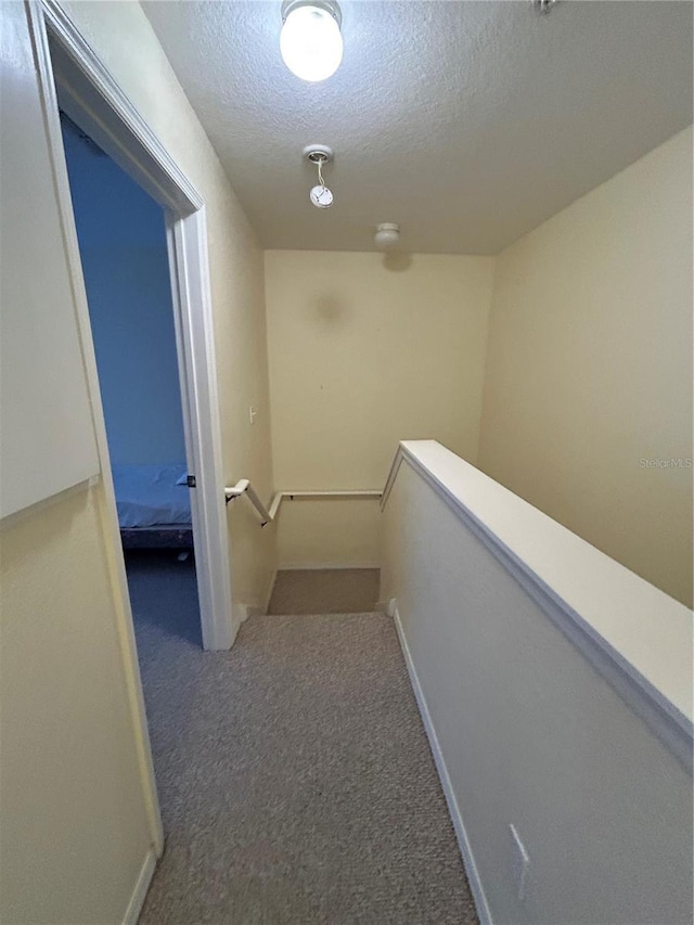 hall with a textured ceiling and carpet