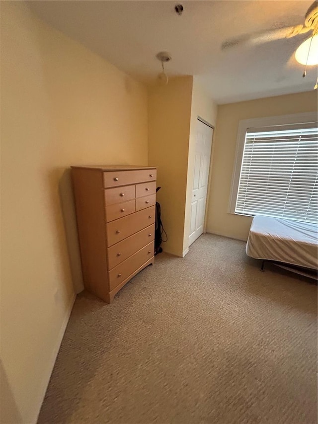 unfurnished bedroom featuring a closet, ceiling fan, and carpet