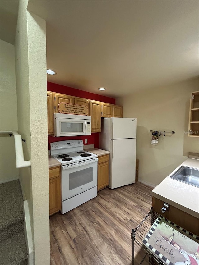 kitchen featuring white appliances, light hardwood / wood-style floors, and sink