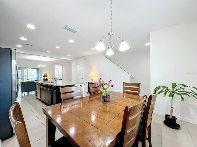 dining space with light tile patterned flooring, sink, and a notable chandelier