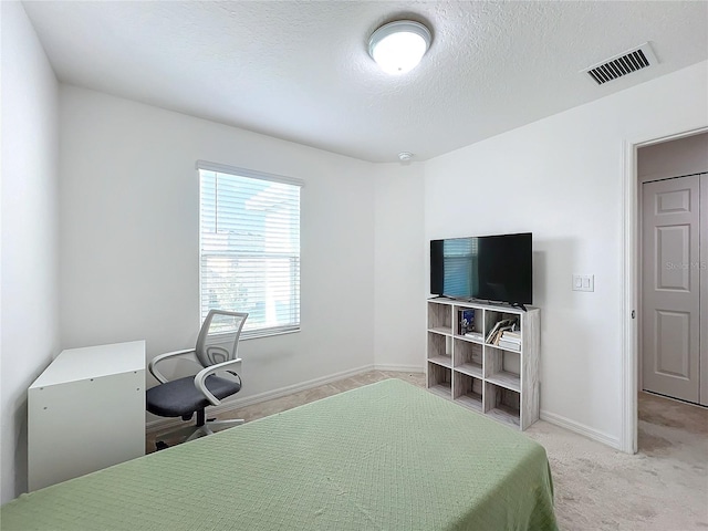 carpeted bedroom featuring a textured ceiling