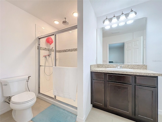 bathroom featuring a shower with door, vanity, tile patterned floors, and toilet