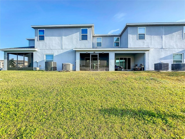 back of house with a sunroom, central AC unit, and a lawn