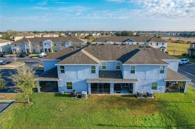 rear view of property featuring cooling unit and a yard