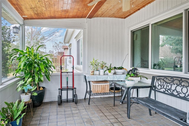 sunroom with lofted ceiling, wooden ceiling, and ceiling fan