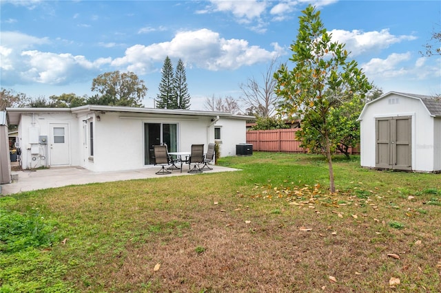 back of property with a patio, central air condition unit, a shed, and a lawn