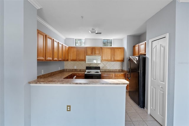 kitchen with electric stove, light tile patterned floors, black refrigerator, and kitchen peninsula