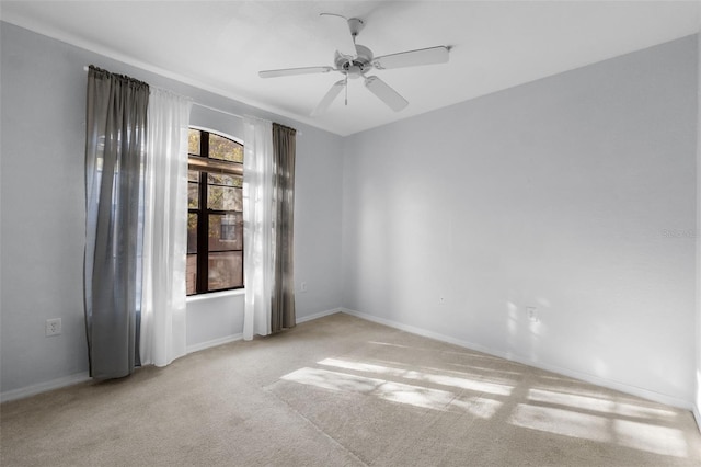 empty room featuring light colored carpet and ceiling fan