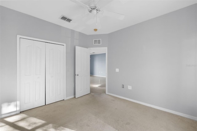 unfurnished bedroom with ceiling fan, light colored carpet, and a closet