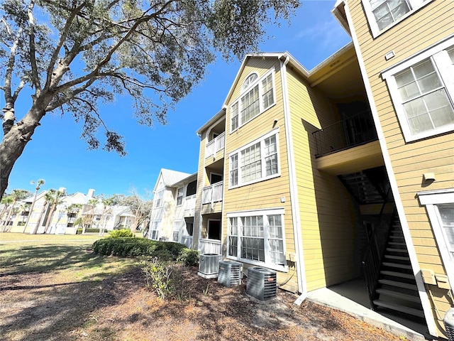 view of property with central air condition unit, stairs, and a residential view