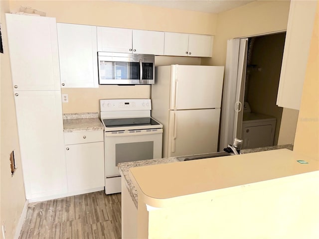 1091 S Hiawassee Rd Unit 216, Orlando, FL 32835 - kitchen featuring white appliances, white cabinets, a peninsula, light countertops, and light wood-style floors