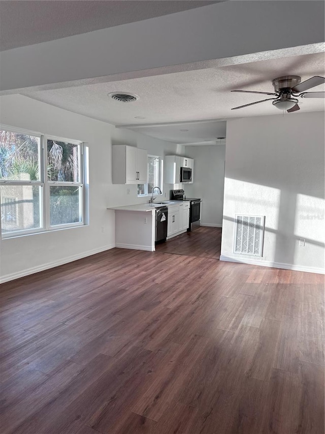 unfurnished living room with a healthy amount of sunlight, visible vents, and a textured ceiling