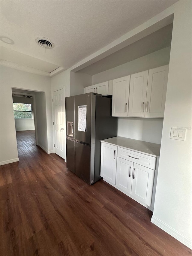 kitchen with white cabinets, visible vents, stainless steel refrigerator with ice dispenser, and dark wood finished floors