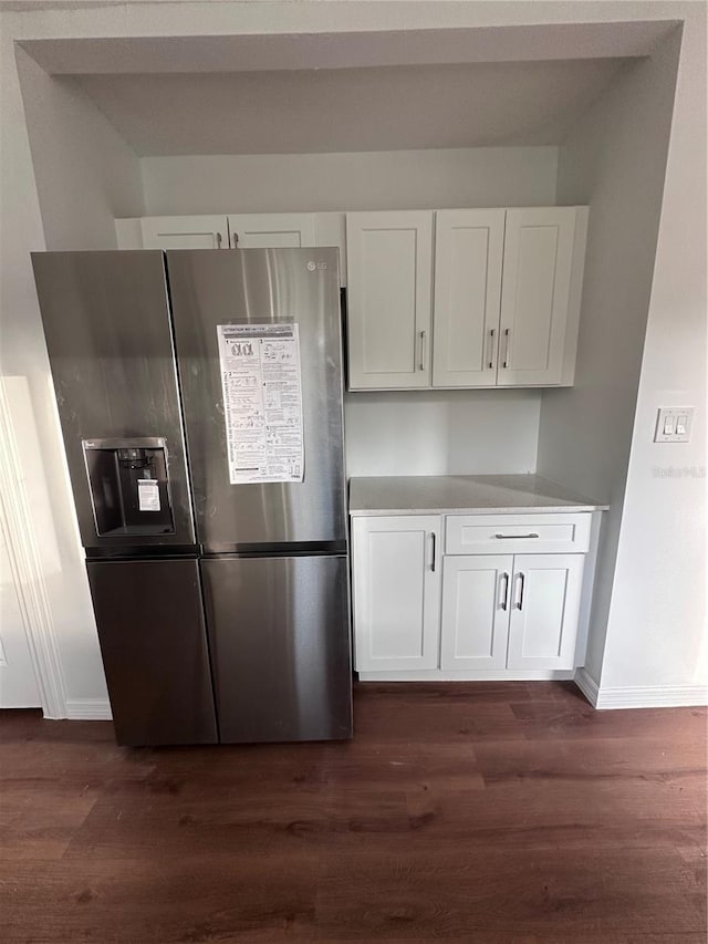 kitchen with baseboards, white cabinets, dark wood-style flooring, light countertops, and stainless steel refrigerator with ice dispenser