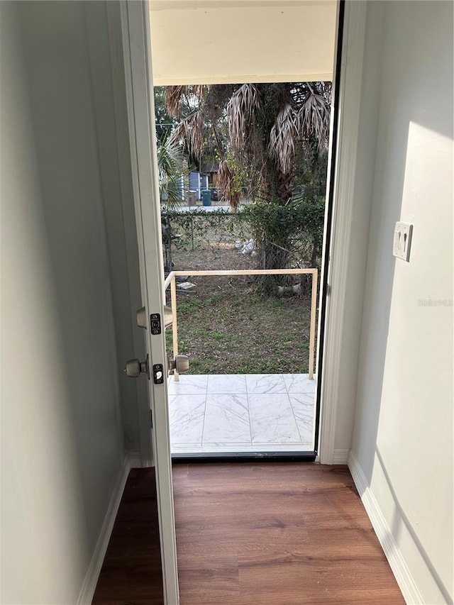 entryway with baseboards and wood finished floors