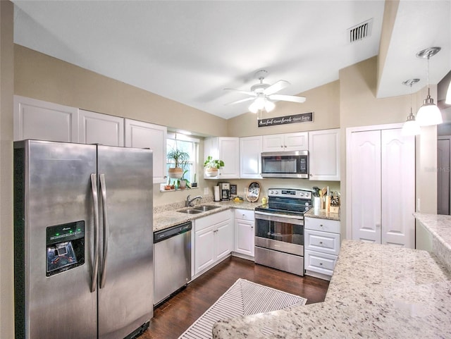 kitchen featuring pendant lighting, sink, white cabinets, light stone counters, and stainless steel appliances