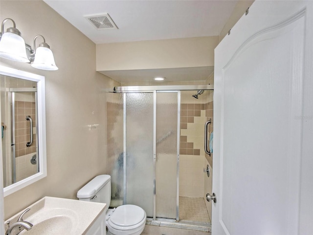 bathroom with vanity, toilet, and a shower with shower door