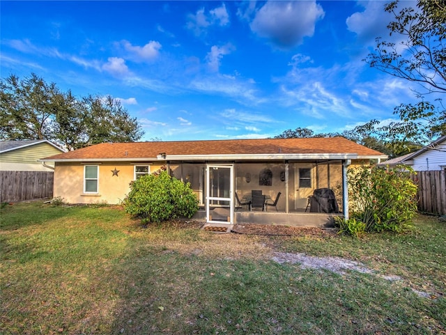 back of house with a yard and a sunroom