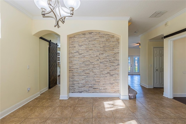 empty room featuring light tile patterned floors, ornamental molding, and a barn door