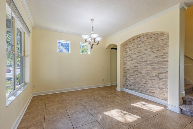 unfurnished room featuring crown molding, tile patterned floors, a chandelier, and a textured ceiling