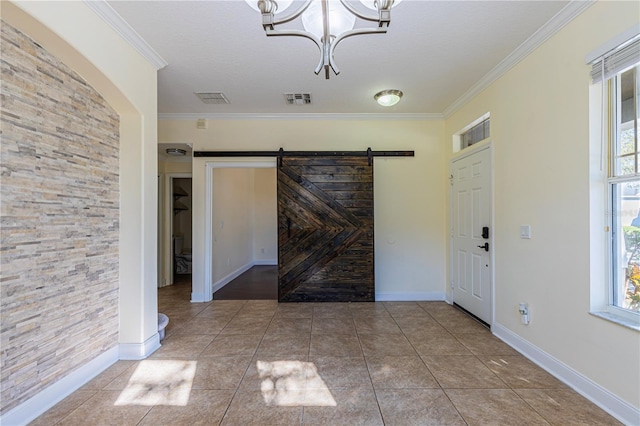 entrance foyer with an inviting chandelier, crown molding, tile patterned floors, and a barn door