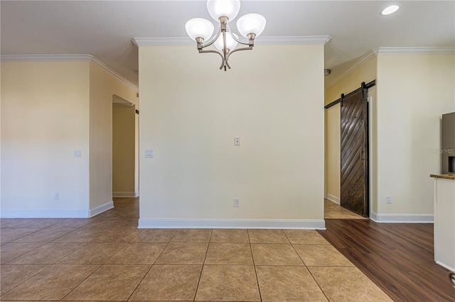 tiled empty room with ornamental molding, a barn door, and a notable chandelier