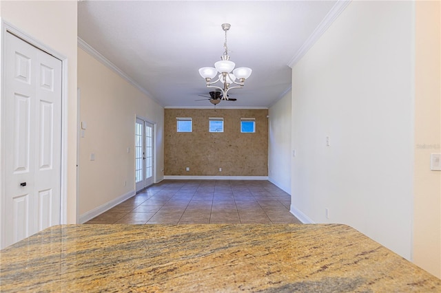 unfurnished dining area with crown molding, dark tile patterned flooring, and an inviting chandelier