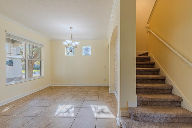 stairway with crown molding, a chandelier, and tile patterned flooring