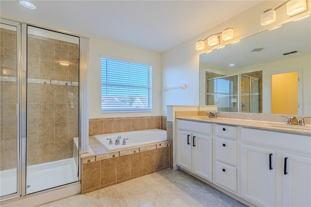 bathroom with vanity and shower with separate bathtub