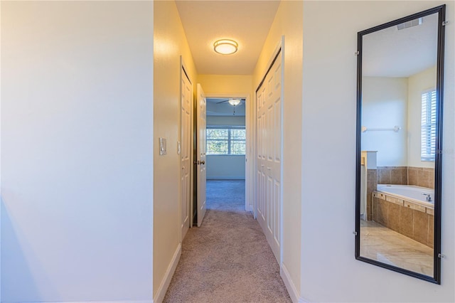 hall featuring light colored carpet