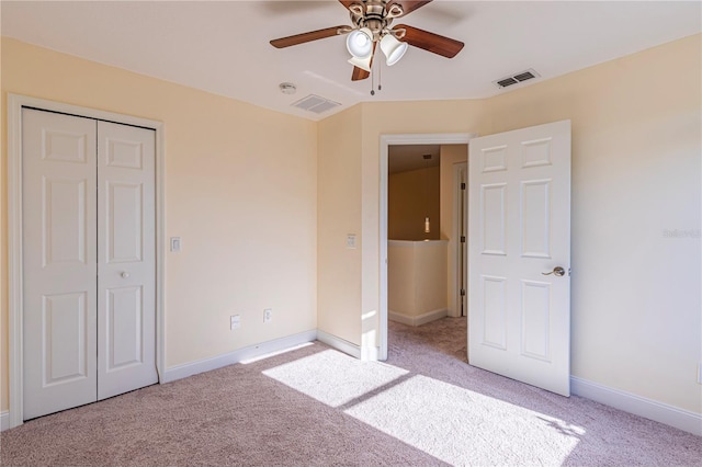 unfurnished bedroom featuring light colored carpet, a closet, and ceiling fan