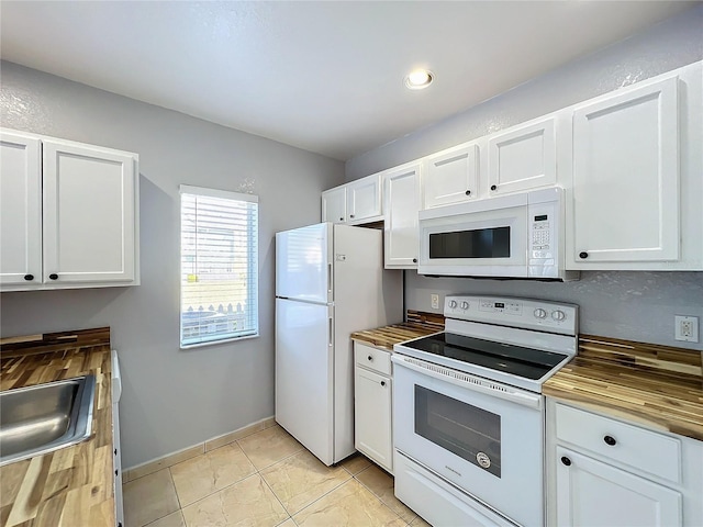 kitchen with wood counters, white cabinets, and white appliances