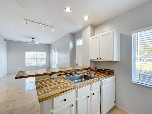 kitchen featuring white cabinetry, dishwasher, butcher block counters, sink, and kitchen peninsula