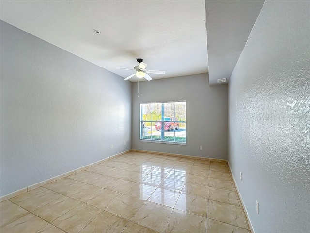 tiled spare room with ceiling fan