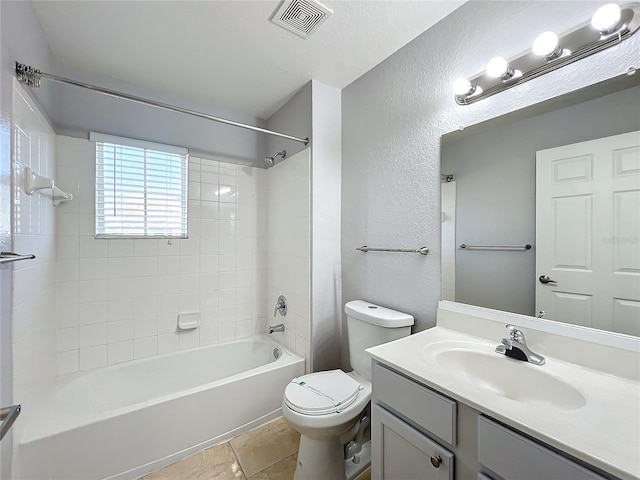 full bathroom featuring tiled shower / bath, vanity, and toilet