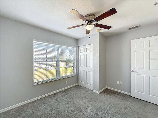 unfurnished bedroom featuring light colored carpet, a closet, and ceiling fan