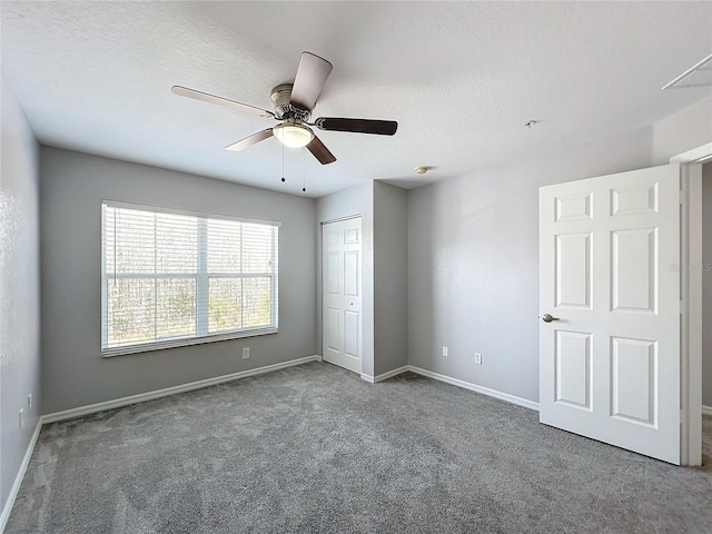 unfurnished bedroom with ceiling fan, carpet floors, a closet, and a textured ceiling