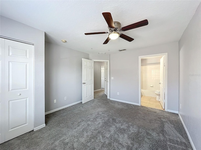 unfurnished bedroom with ceiling fan, ensuite bathroom, and carpet floors