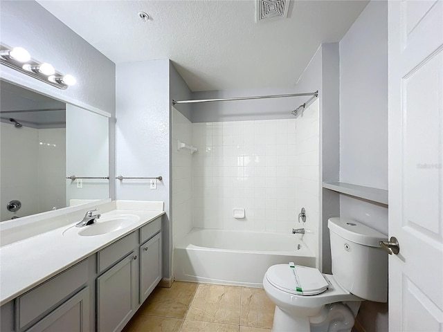 full bathroom with vanity, tiled shower / bath, toilet, and a textured ceiling