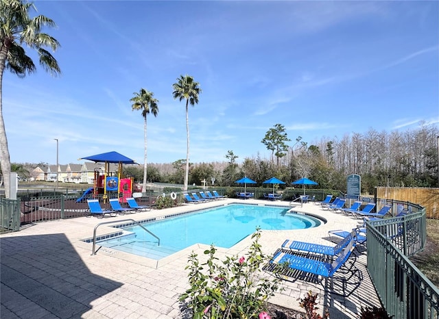 view of pool with a patio area and a playground