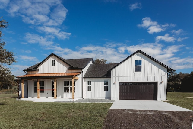 modern farmhouse with a garage, a front yard, and a porch