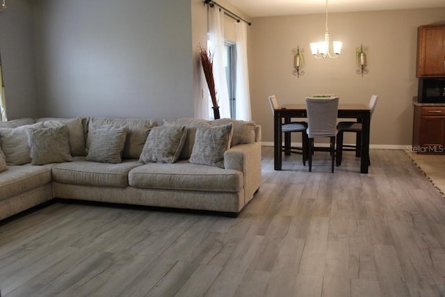 living room featuring light wood-type flooring and a notable chandelier