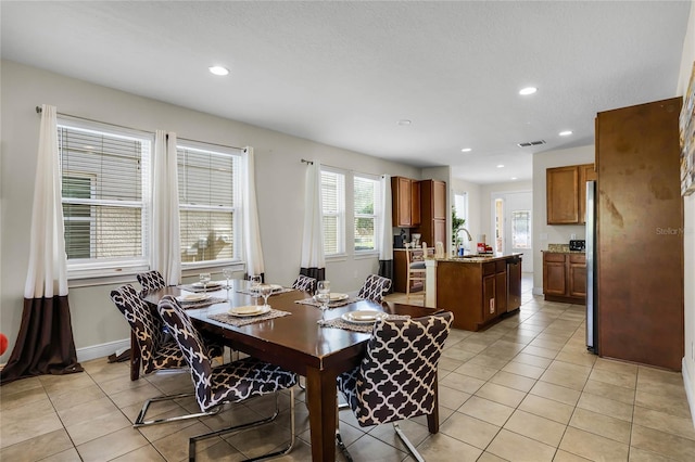 dining area featuring sink and light tile patterned flooring