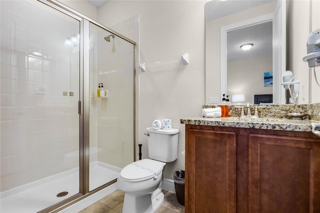 bathroom with tile patterned flooring, vanity, a shower with door, and toilet